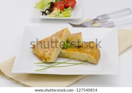 Spanish Cuisine. Spanish Omelette served in slices. Tortilla de patatas. White background.