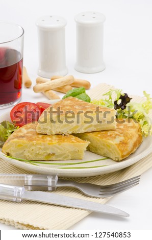 Spanish Cuisine. Spanish Omelette served in slices. Tortilla de patatas. White background. Focus on foreground.