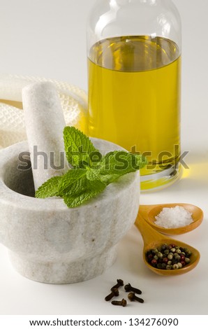 Herbs and spices composition including olive oil, pepper, salt, clove and mint. White background.