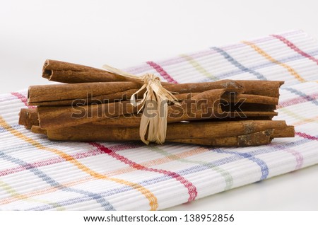 Cinnamon sticks in a bunch. Herbs and Spices. White background. Focus on Foreground.