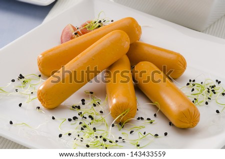 Vegetarian tofu sausage on a ceramic plate. Soy products. Focus on foreground.