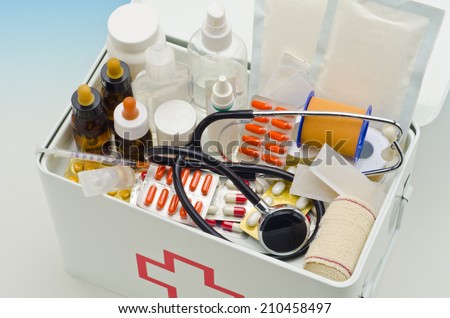 Open first aid box filled with medical supplies in blue background