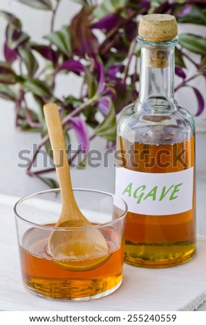 Agave syrup in a glass. Alternative sweetener to sugar. Selective focus. White background. Taken in daylight.