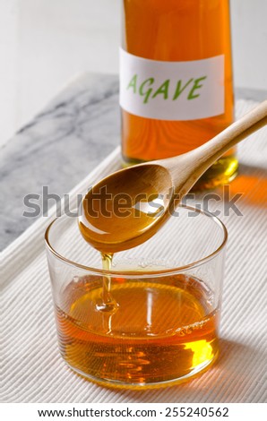 Agave Syrup pouring on a glass. Alternative sweetener to sugar. Selective focus.