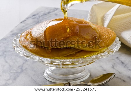Agave Syrup pouring on a plate of pancakes. Alternative sweetener to sugar. Selective focus.