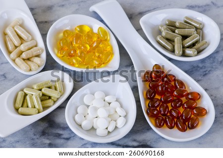 Variety of dietary supplements, including capsules of Garlic, Evening Primrose Oil; Artichoke Leaf;  Olive Leaf; Magnesium and Omega 3 Fish Oil.Selective focus. Taken in daylight.