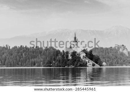 RETRO PHOTO FILTER EFFECT: Church on Island in Lake Bled, Slovenia, with Castle and mountains in distance