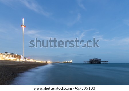 Night Photo of Brighton Skyline with old West Pier, Central Pier with fun fair lights and the new i360 attraction , Brighton, Sussex, England, UK