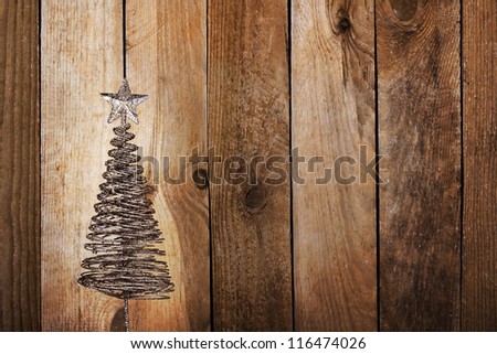 Christmas greeting card with gold metal firtree on the wooden background