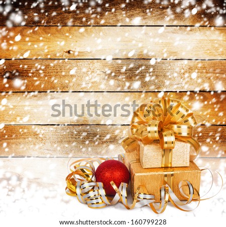 Snow-covered wooden wall with a beautiful gift box and bow