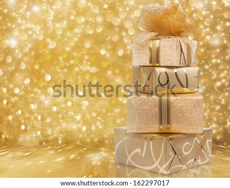 Beautiful gift boxes in gold paper with a silk rose on abstract background