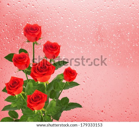 Bouquet of red roses on the background of a window with raindrops