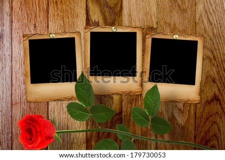 Old grunge paper slide on the wooden background with beautiful red rose