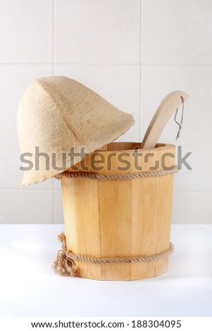 Wooden bucket with ladle for the sauna on white background