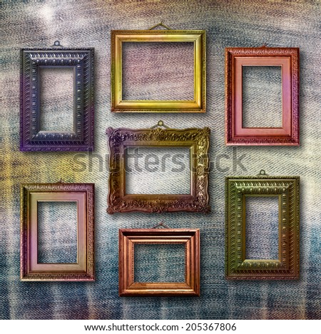 Gilded wooden frames for pictures on blue jeans background