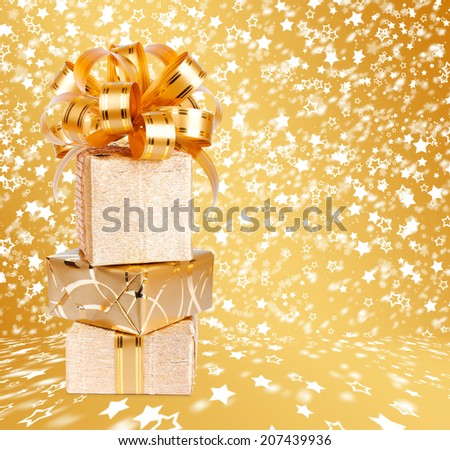 Gift box in gold wrapping paper on a beautiful  abstract background