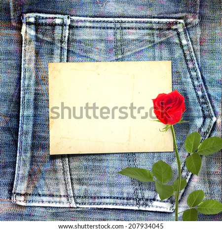 Old vintage postcard with beautiful red rose on blue jeans background