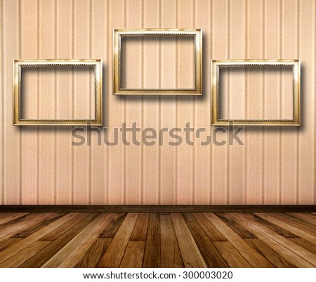 Interior of room with striped wallpaper and gold wooden frames for paintings