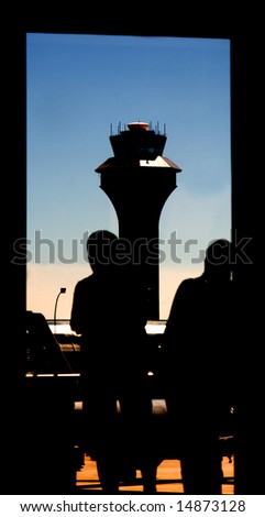 Silhouette of Airport Tower and Passengers Waiting captured in this uniquely framed picturesque of the aviation transportation industry.