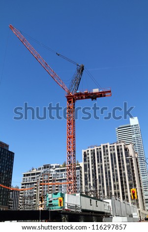 high-rise building crane on top of building construction site