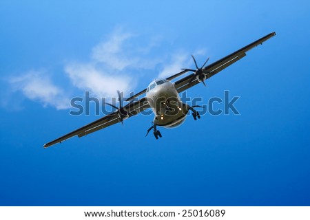 propeller airplane landing in cloudy blue sky