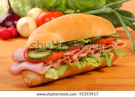 Delicious ham, cheese and salad sandwiches on a wooden board