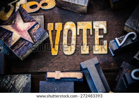 The word VOTE written in rusted metal letters surrounded by vintage wooden and metal letterpress type.
