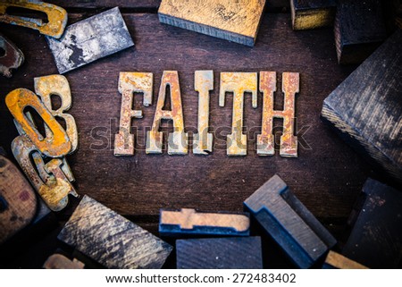 The word FAITH written in rusted metal letters surrounded by vintage wooden and metal letterpress type.