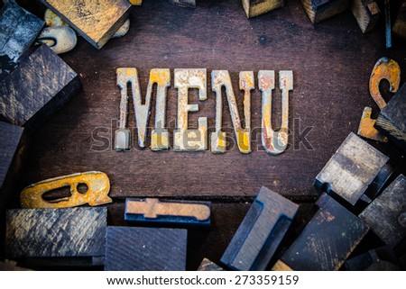 The word menu written in rusted metal letters surrounded by vintage wooden and metal letterpress type.