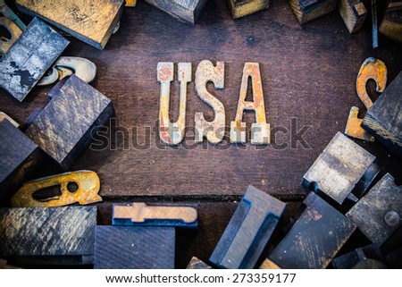 The letters USA written in rusted metal letters surrounded by vintage wooden and metal letterpress type.