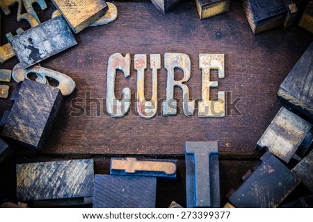 The word CURE written in rusted metal letters surrounded by vintage wooden and metal letterpress type.