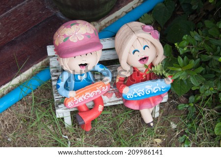 Child ceramic doll Holding signs that say hello Thailand.