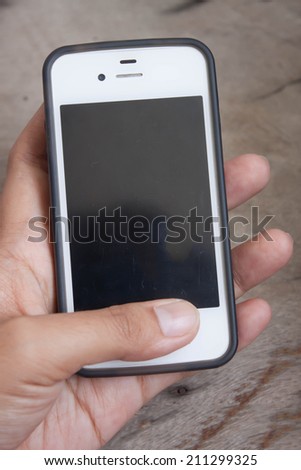Smart phones in the hands of white women. Wood background