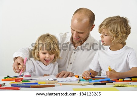 Father teaches his young son how to hold a pen