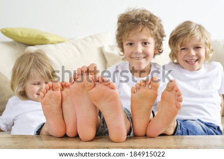 three young boys have their feet on the table