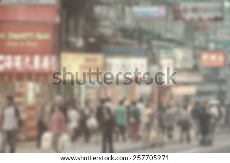 Blurred city background suitable as a background for text. Designed to work with most text colors including white. Artistic intent with filters and desaturation. Pedestrians. Shops