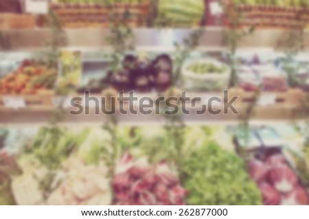 Blurred background of vegetable shelves in a shop. Designed to work with text overlays including the text colour white. Artistic intent with filters and desaturation.