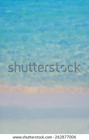 Blurred background of sea shore with calm wave. Designed to work with text overlays including the text colour white. Artistic intent with filters and desaturation.