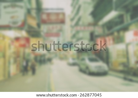Blurred city background suitable as a background for text. Designed to work with most text colors including white. Artistic intent with filters and desaturation. Shop signs. Cars and pedestrians