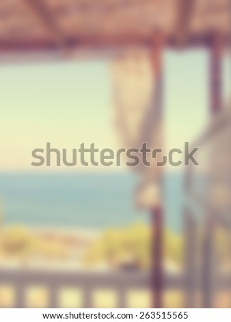 Blurred background with a view to the sea from a balcony. Designed to work with text overlays including the text colour white. Artistic intent with filters and desaturation.