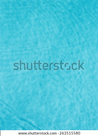 Blurred background of a swimming pool water from above. Designed to work with text overlays including the text colour white. Artistic intent with filters and desaturation. Ripples on the water.