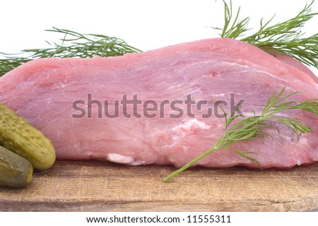 Raw pork schnitzel with pickled cucumbers and dill on a wooden hardboard isolated on white. Close-up