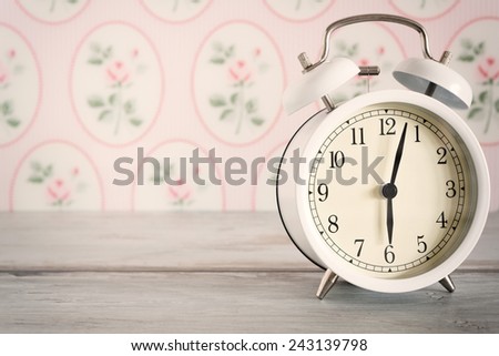 Retro alarm clock on table front wallpaper background