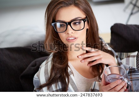 Close up portrait of cute girl with coffee mug next to window with sea view.