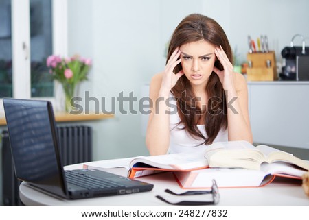 Young student woman with lots of books studying for exams
