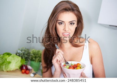 woman is eating a salad in bowl, indoor