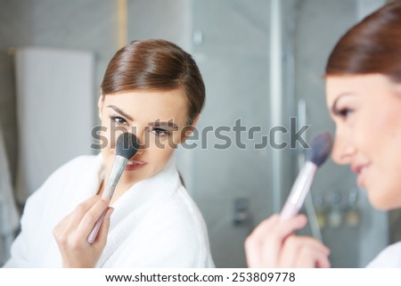 Woman applying make up with cosmetic brush