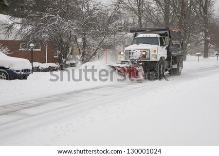 Snow plow removing snow from street.