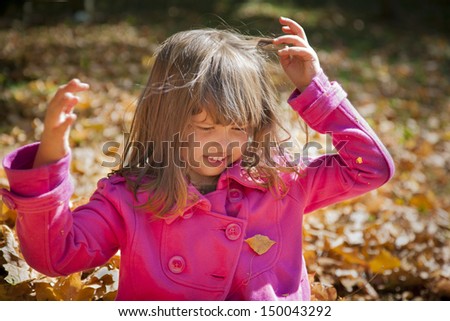 Little Girl Removing Leaves From Her Hair