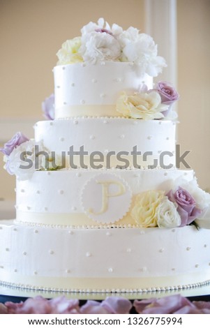 White wedding cake with yellow, white, and purple flowers. wedding cake series